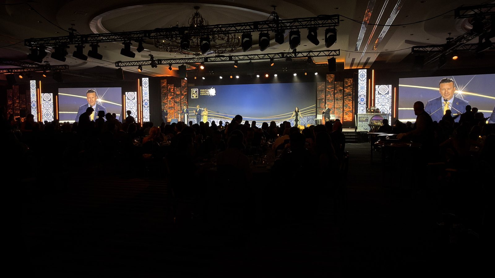 Ballroom gala stage with LED wall backdrop and full seated audience
