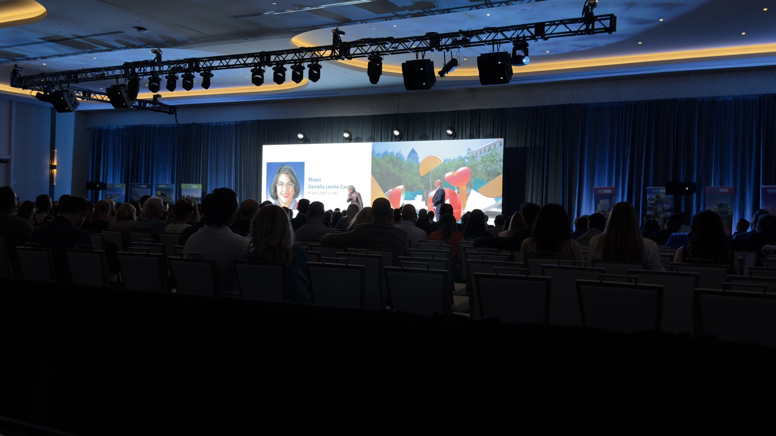 General session audience watching Miami-Dade Mayor Daniella Levine Cava on the main stage screen