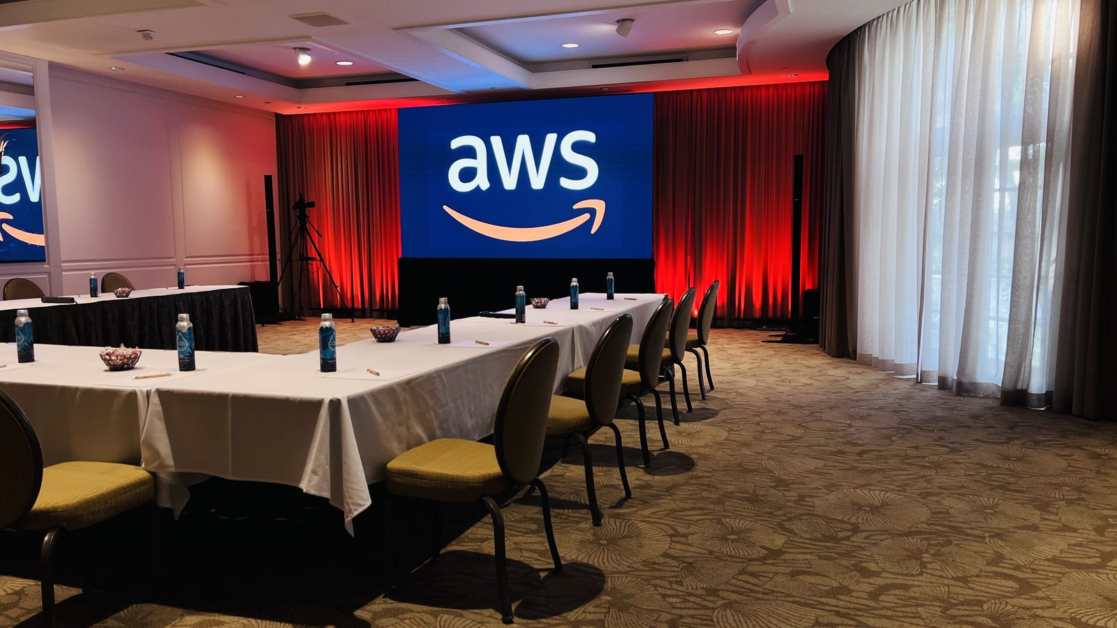 Meeting room set for a corporate breakout session with branded screen