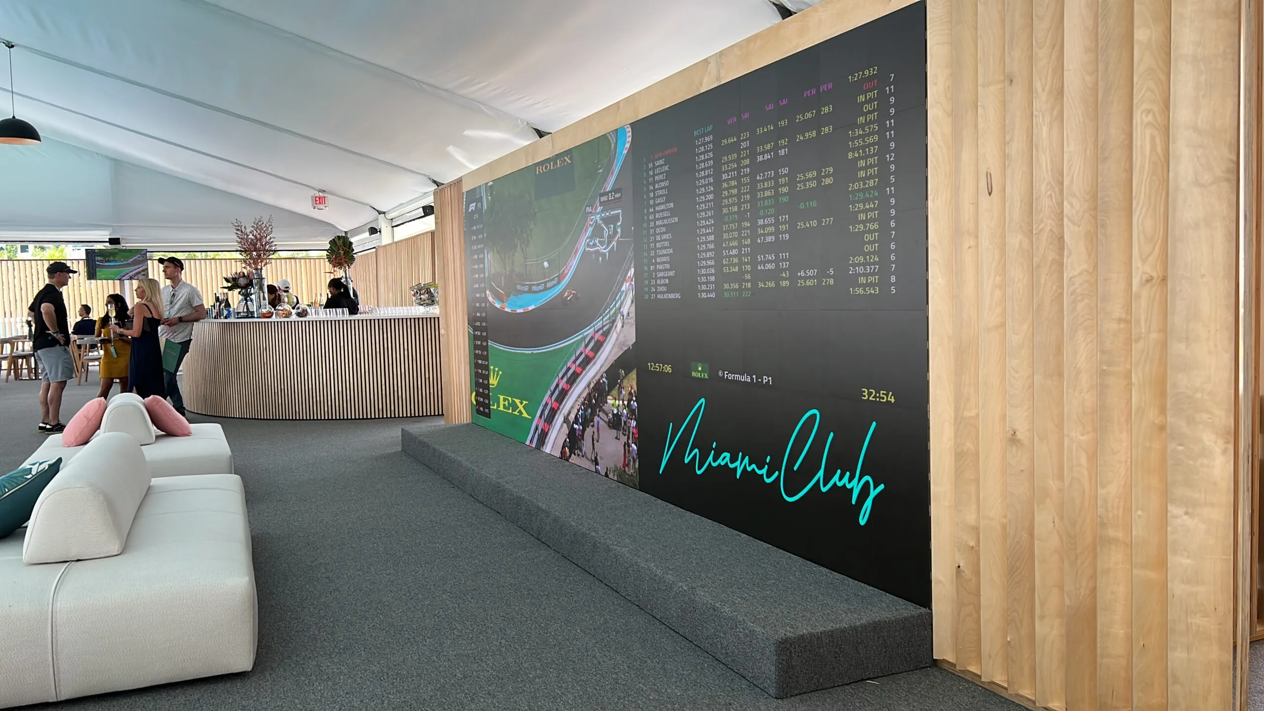 Outdoor lounge activation with a long LED wall behind a white sofa