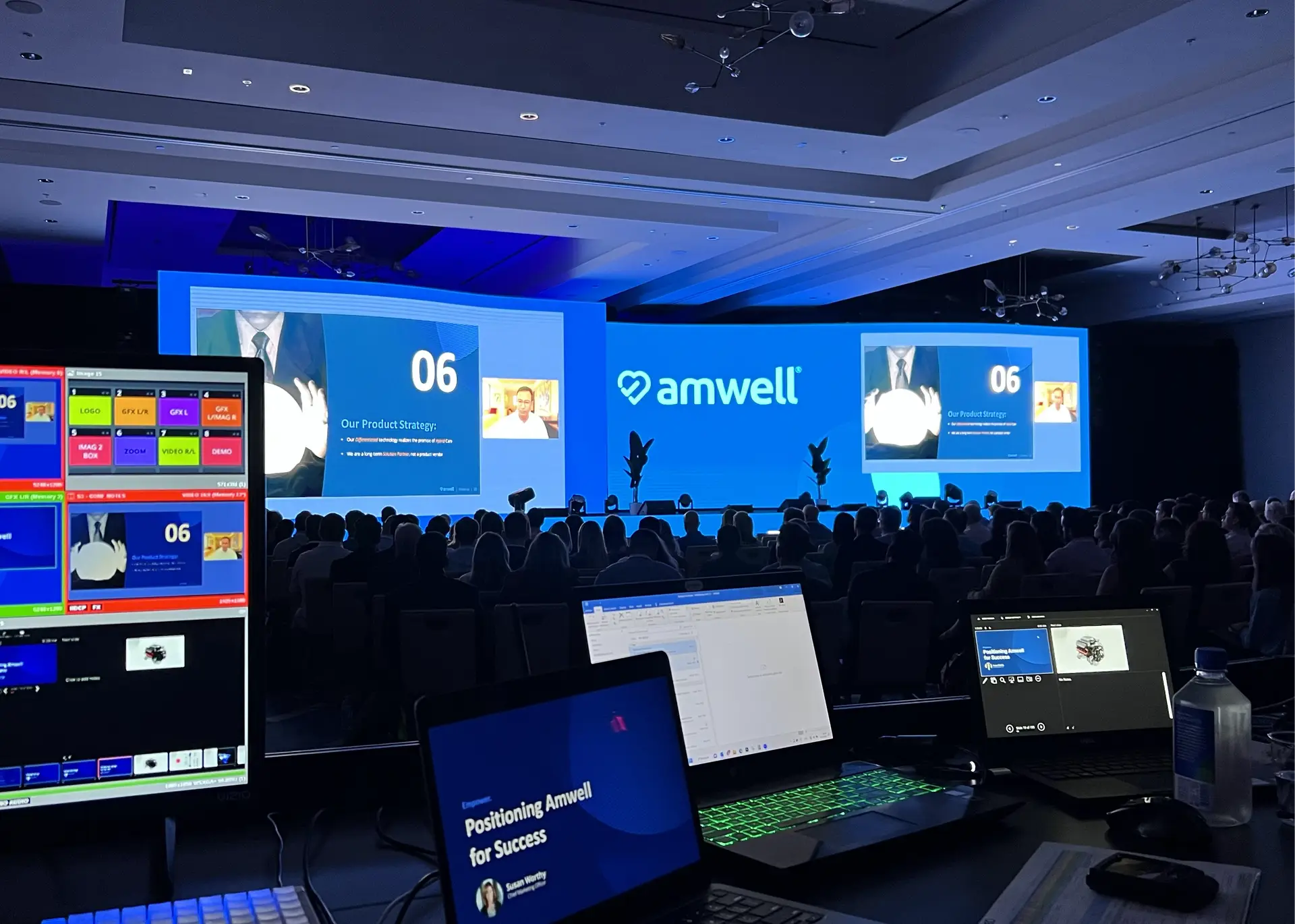 General session with a large blue presentation screen and seated audience